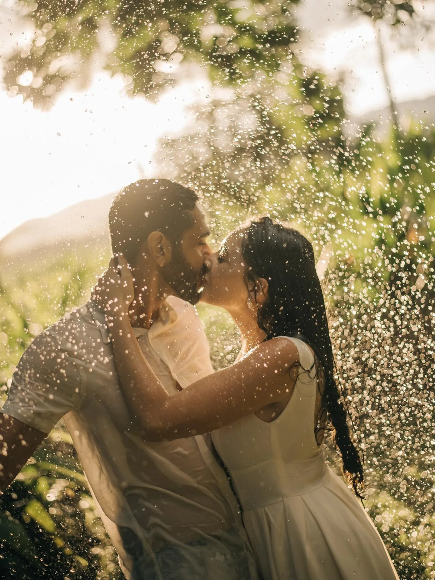 Casal sob gotas de água e luz do sol
