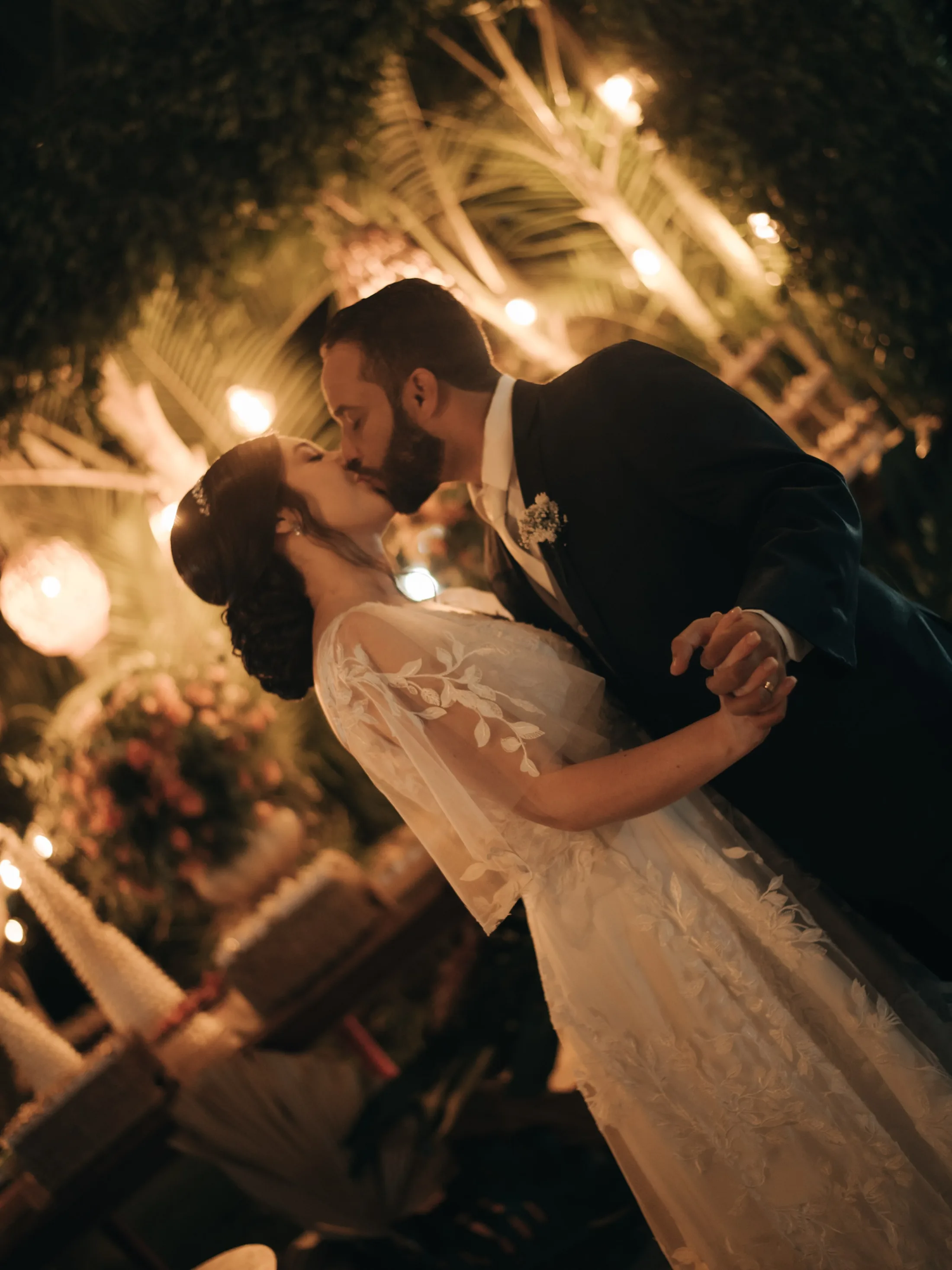 Casal dançando sob luzes quentes na recepção