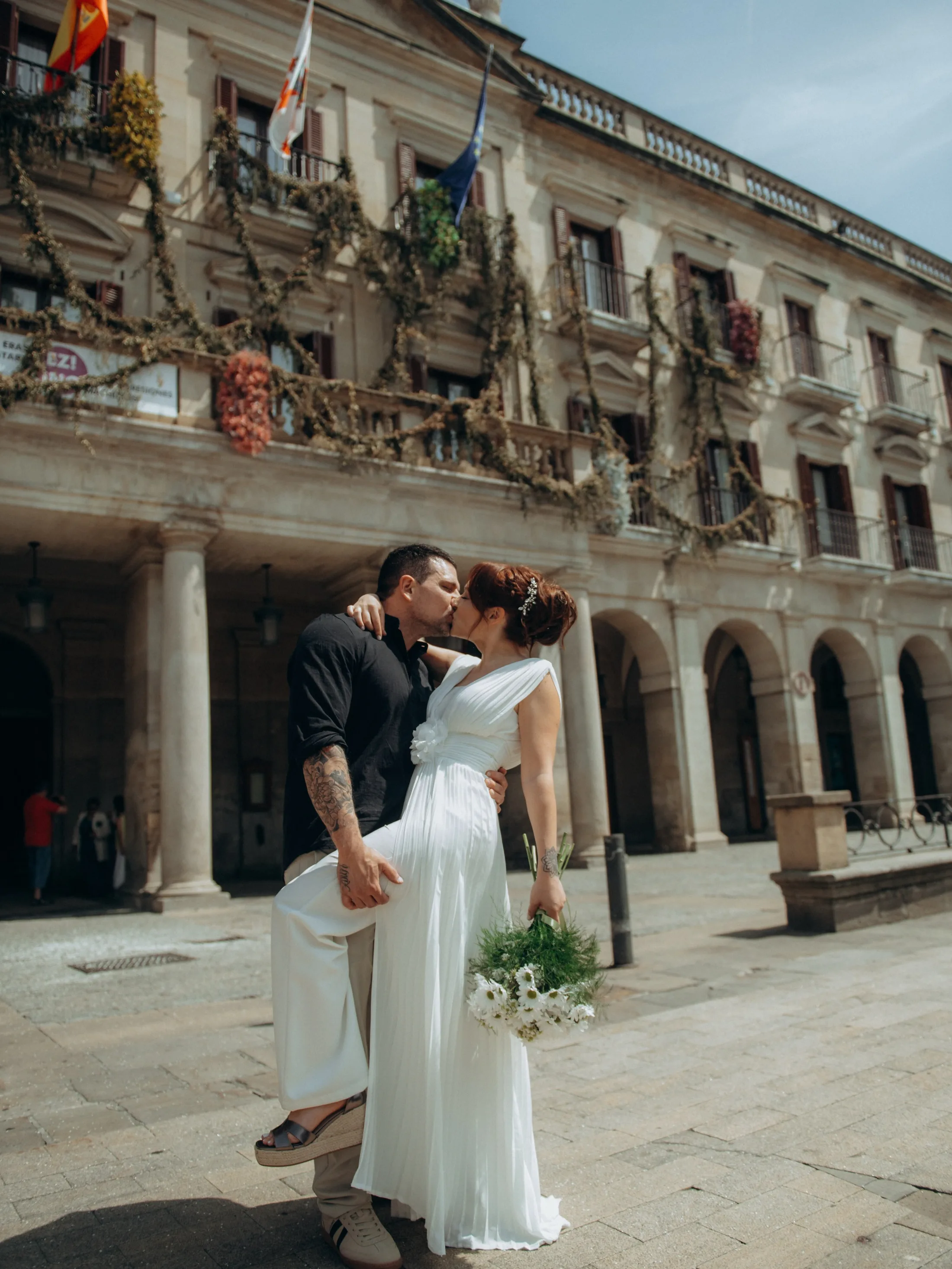 Casal se beijando diante de um edifício com arcos