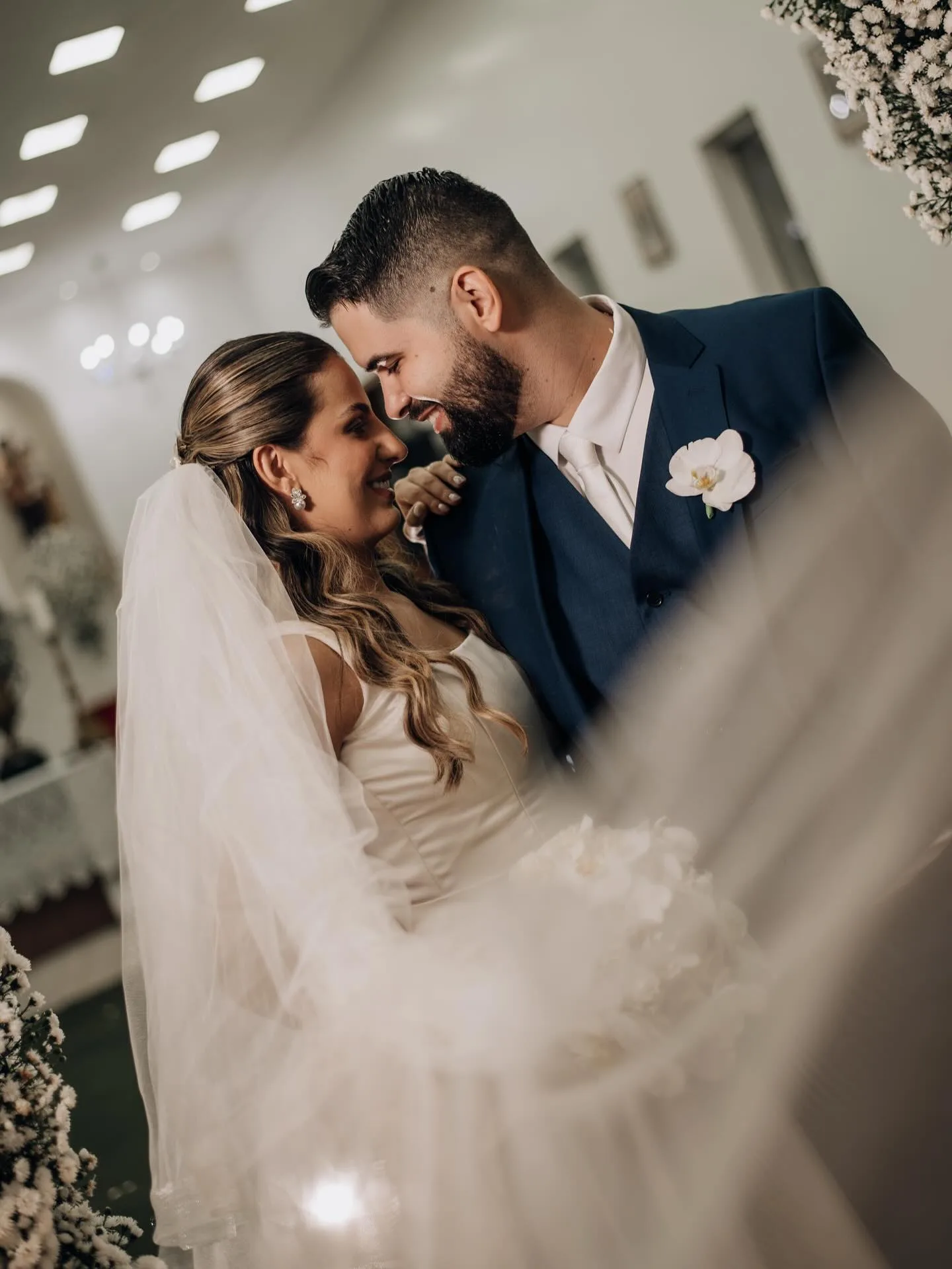 Noivos se beijando sob o véu