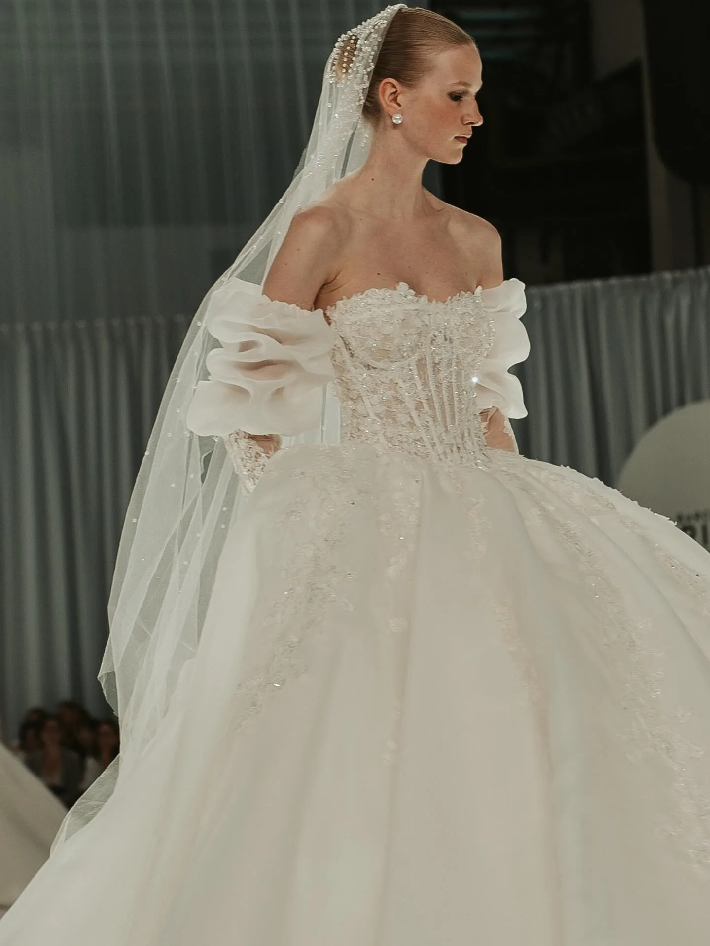 Modelo de perfil com vestido de noiva em desfile
