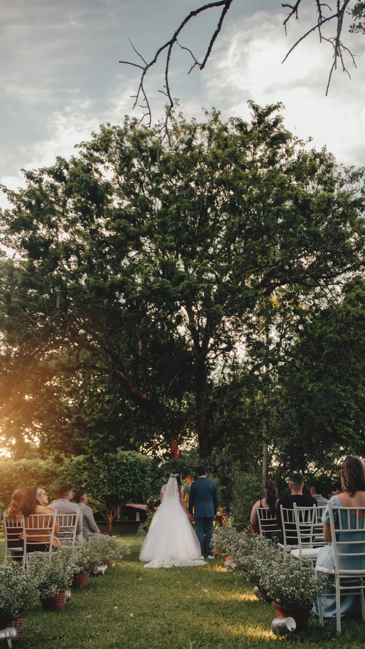 Casal sob arco floral em cerimônia ao ar livre