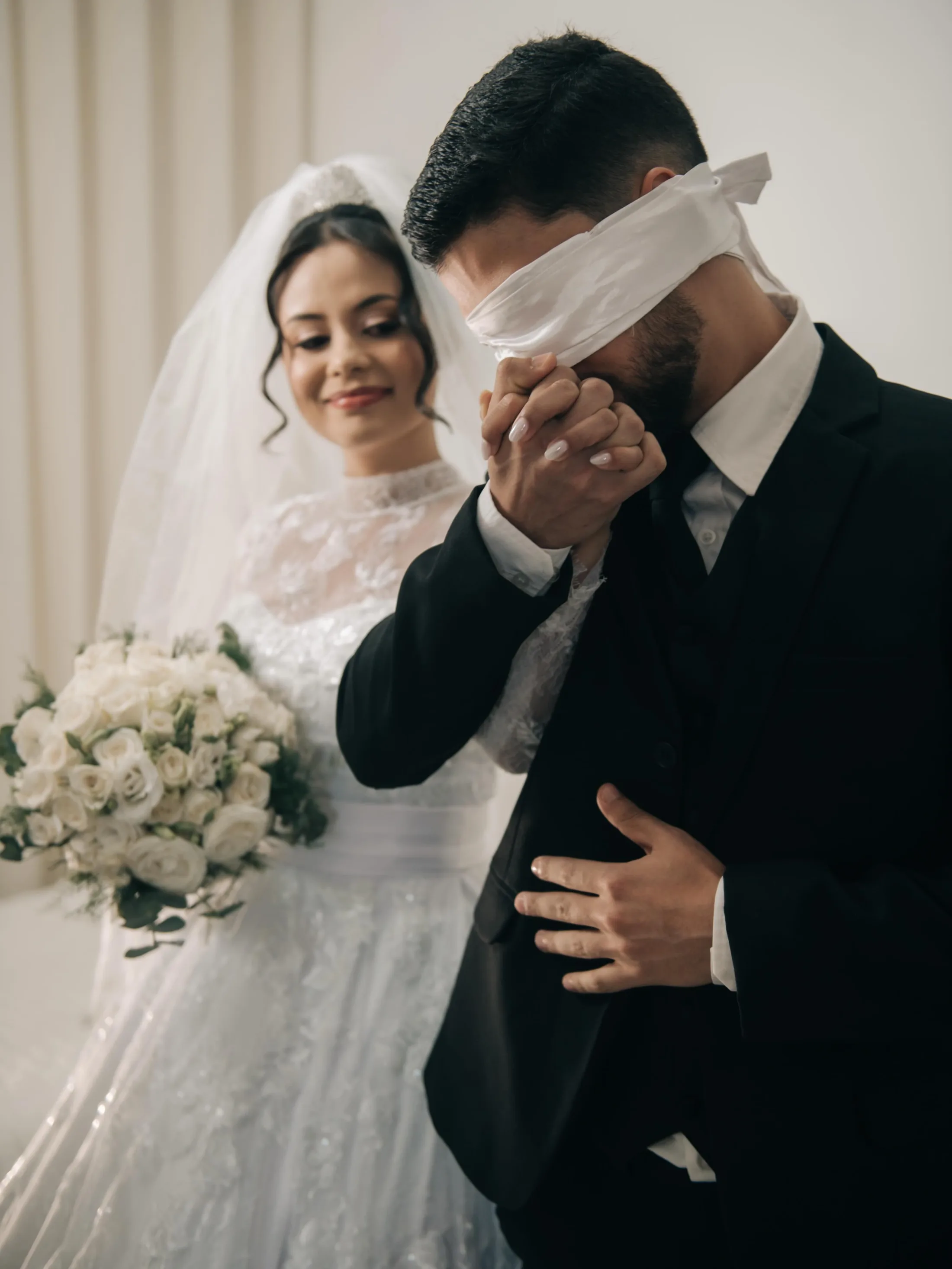 Noiva segurando o braço do noivo sob o véu