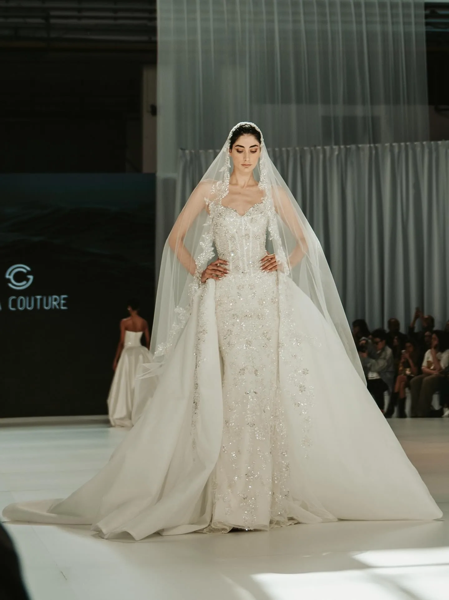 Modelo com véu e vestido de noiva durante desfile