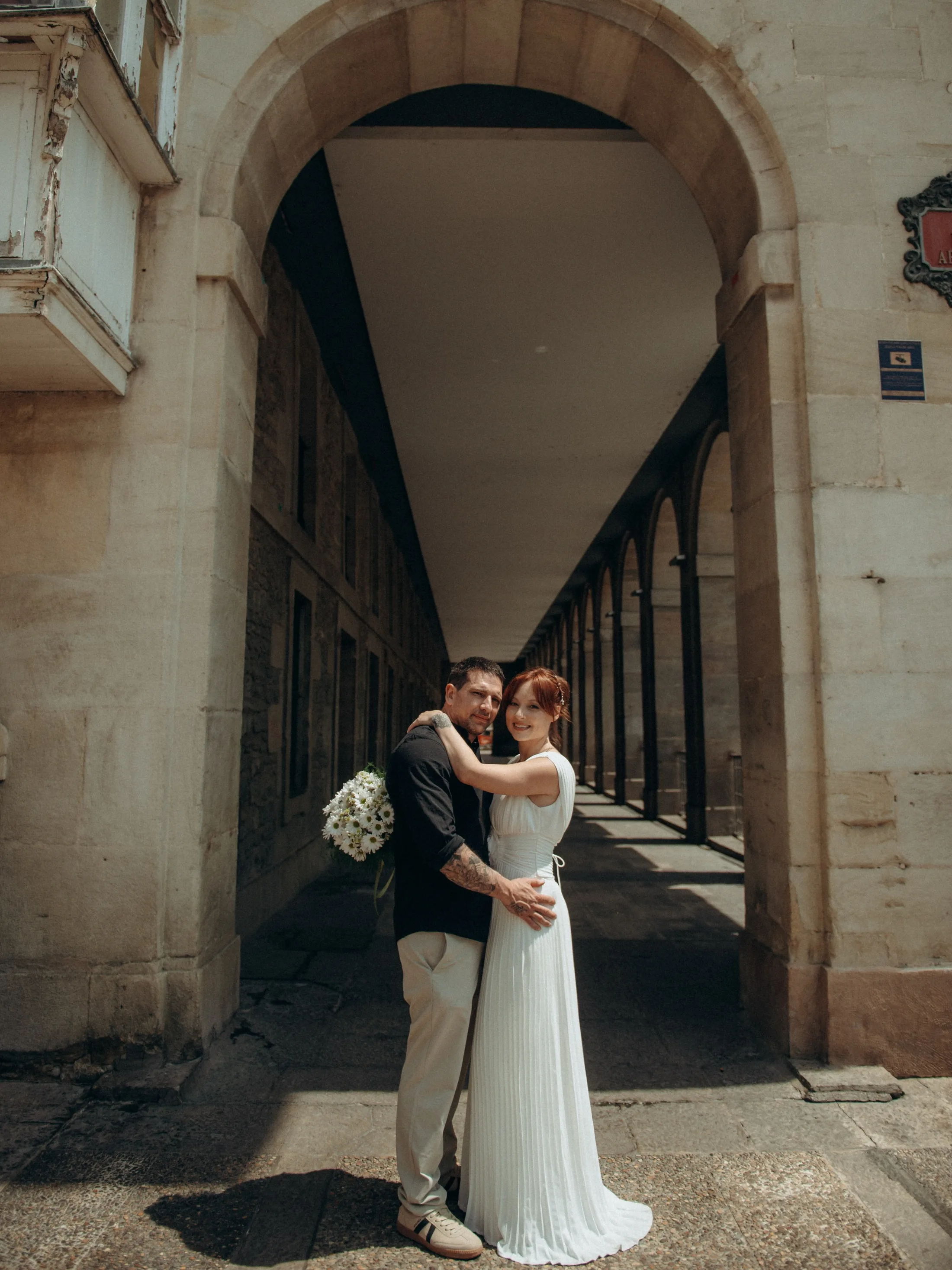 Casal abraçado sob um arco de pedra