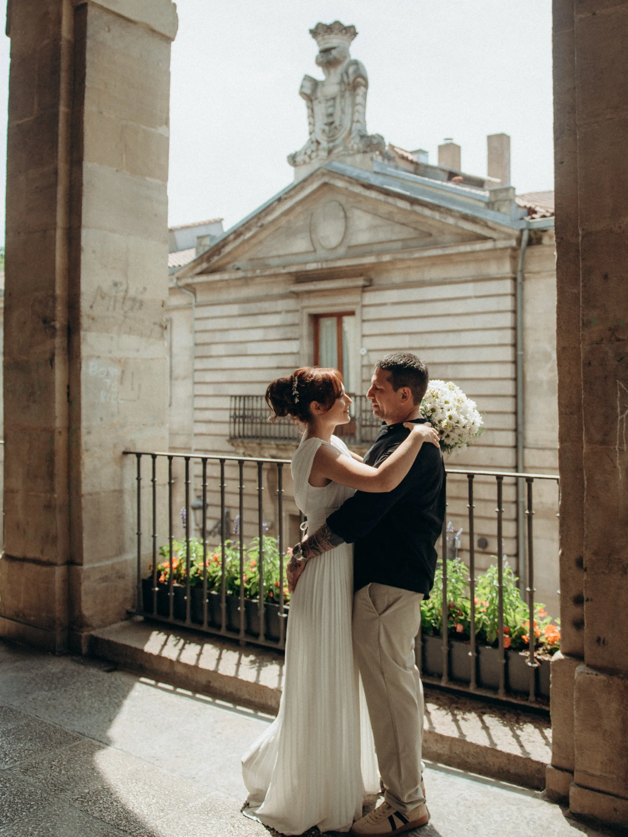 Casal se beijando em varanda com arquitetura ao fundo
