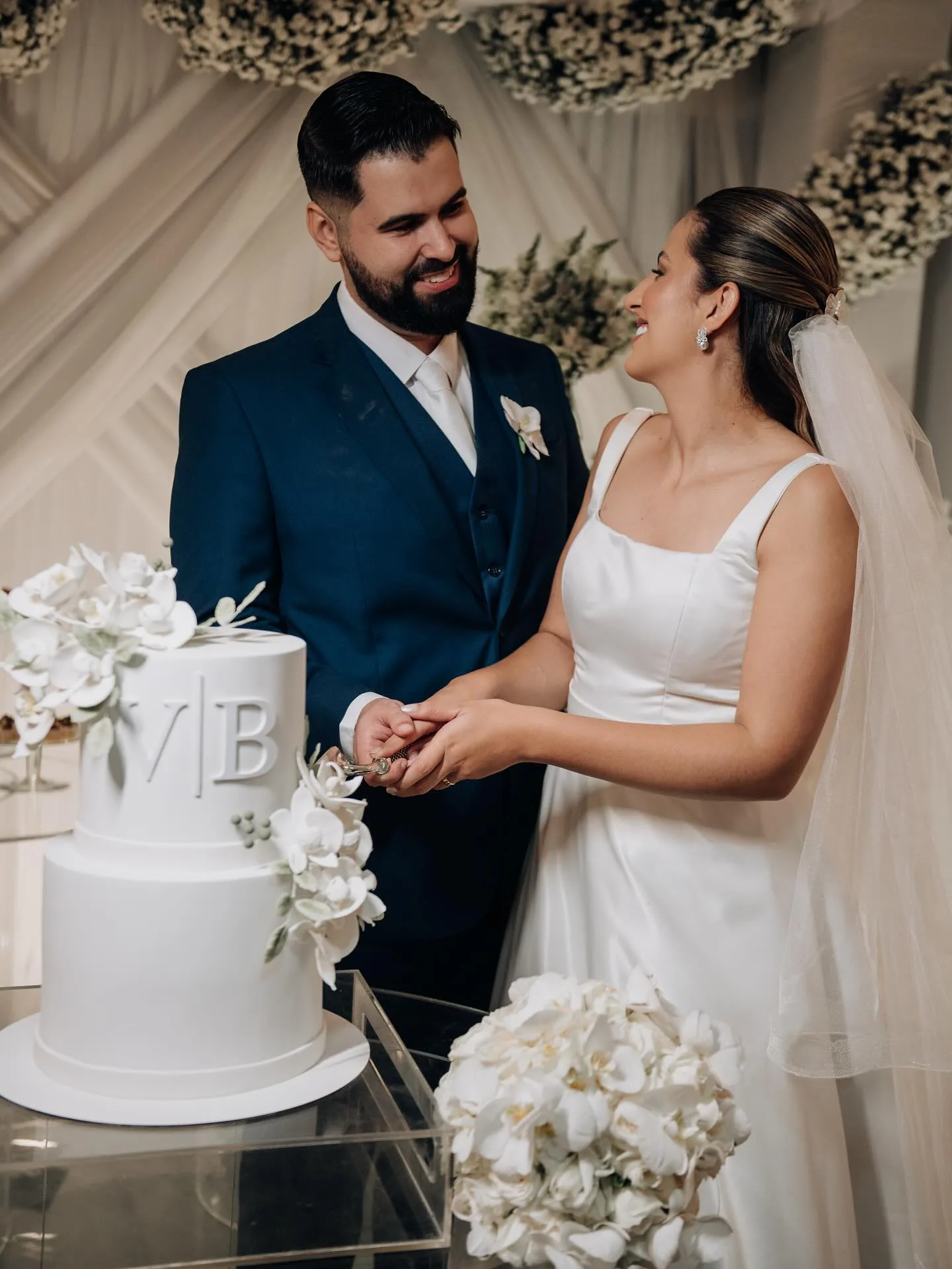 Noivos ao lado do bolo de casamento