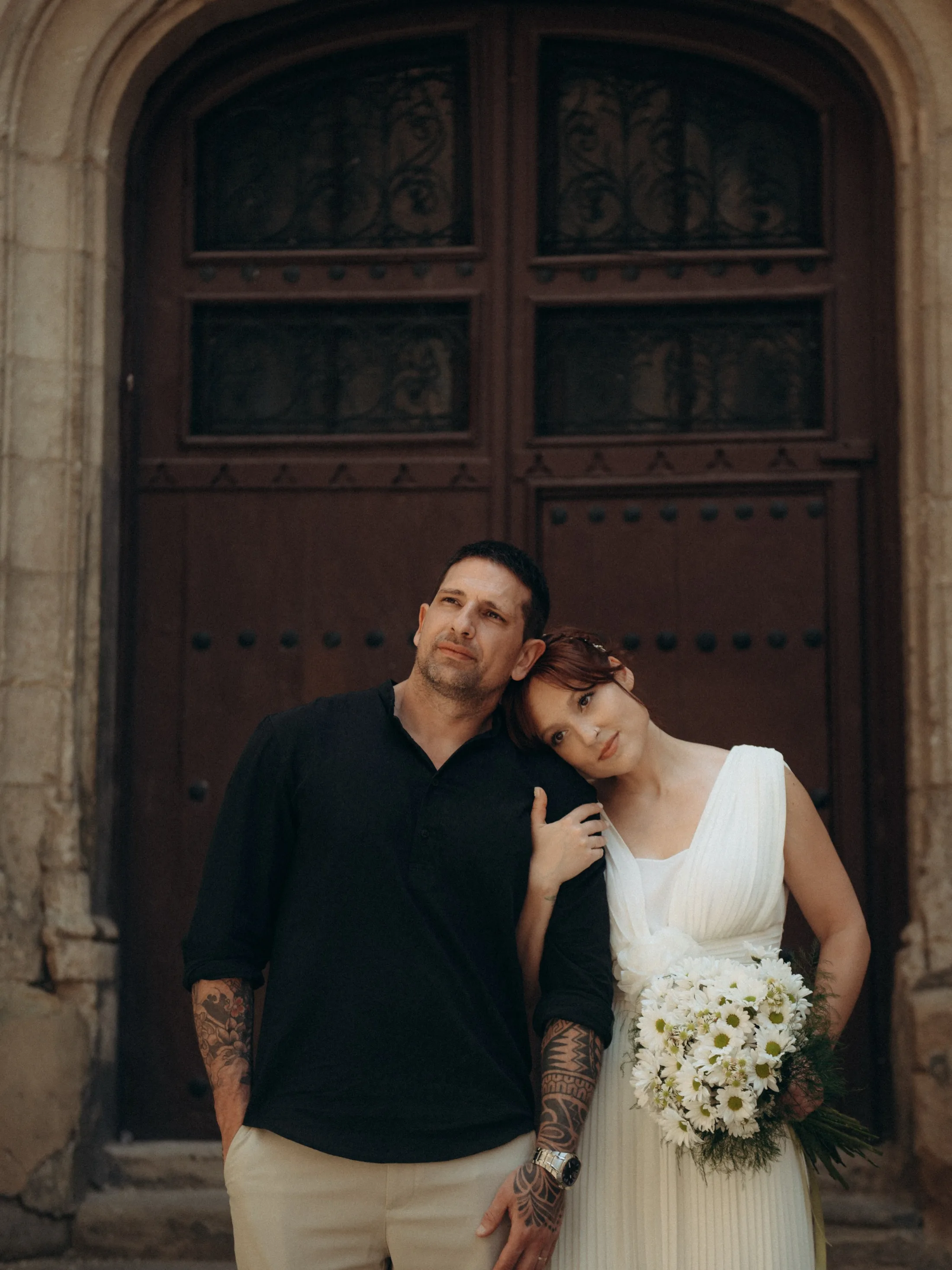 Casal abraçado diante de uma porta de madeira