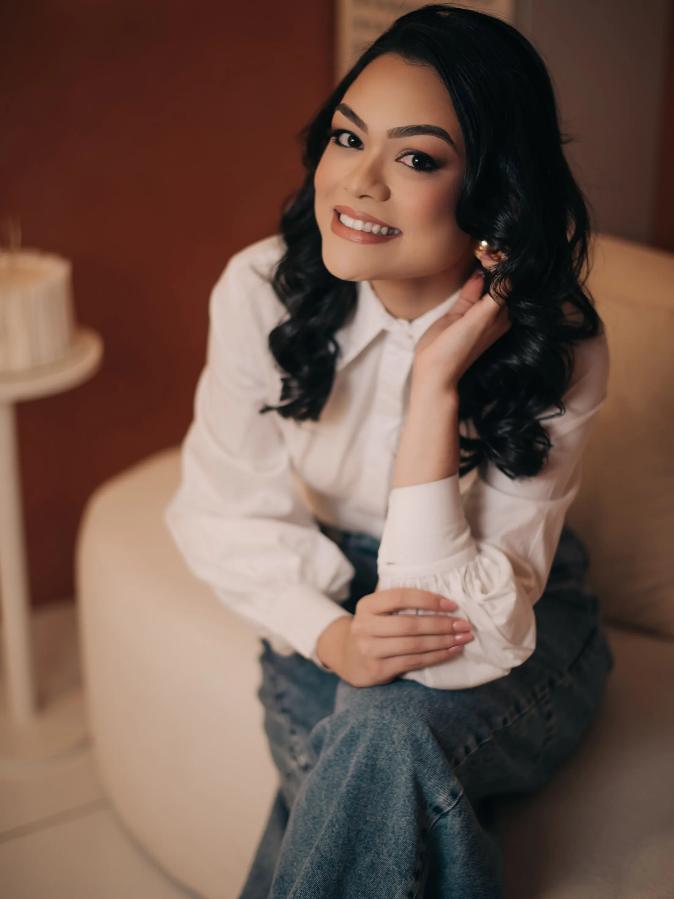 Mulher sorrindo apoiada em uma mesa com bolo