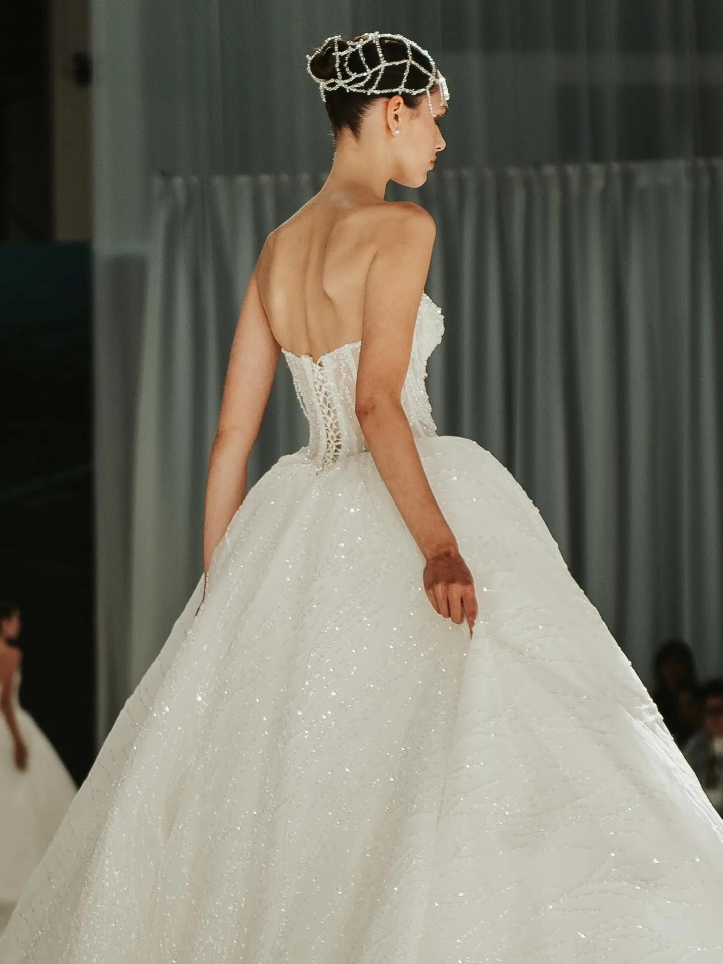 Modelo de costas com vestido de noiva e véu