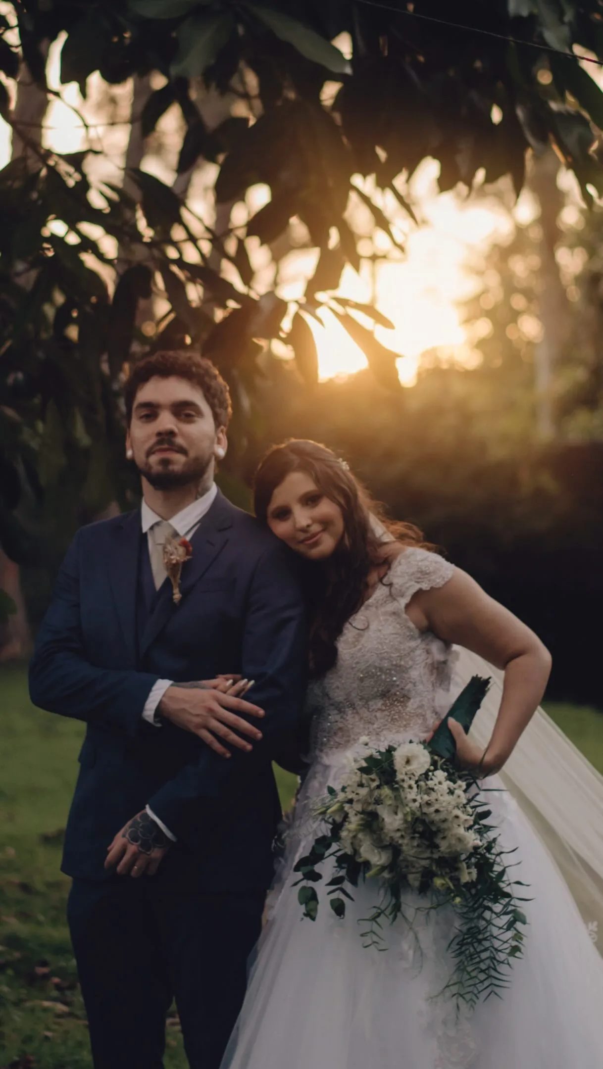 Casal sob árvores com luz de fim de tarde