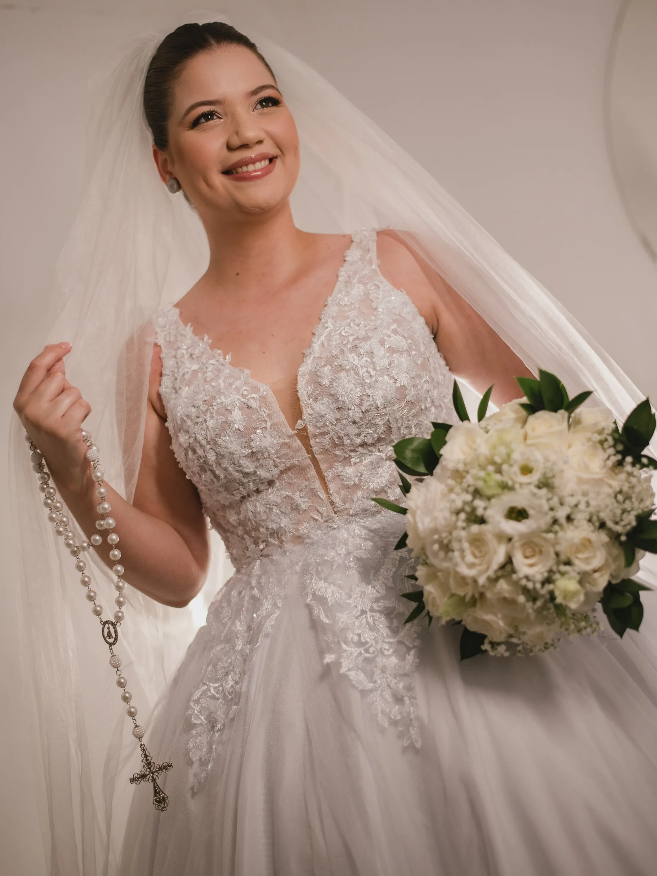 Noiva sorrindo e segurando o buquê