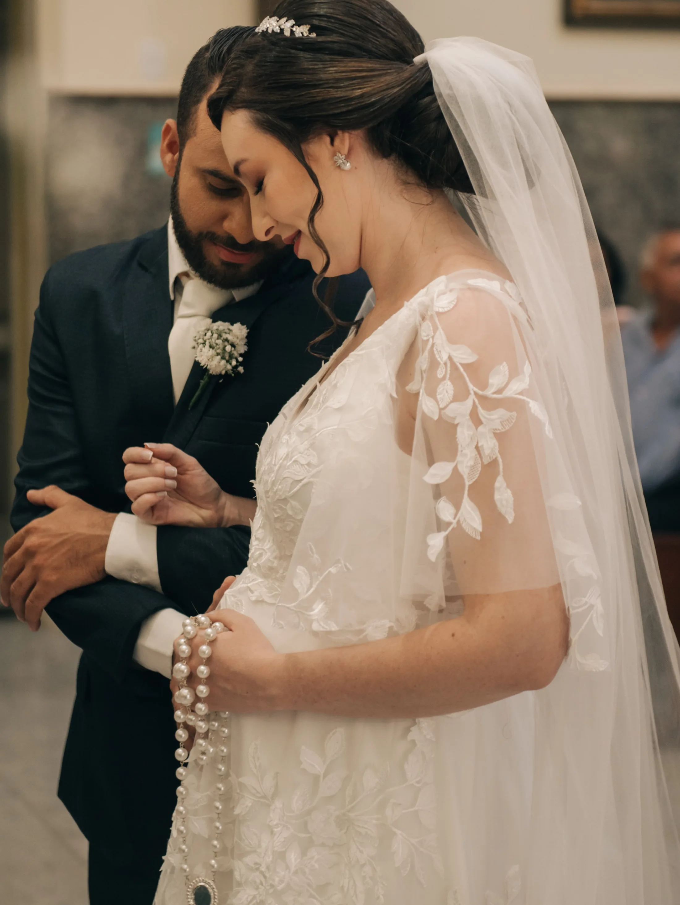 Noivos de mãos dadas com a noiva olhando para baixo