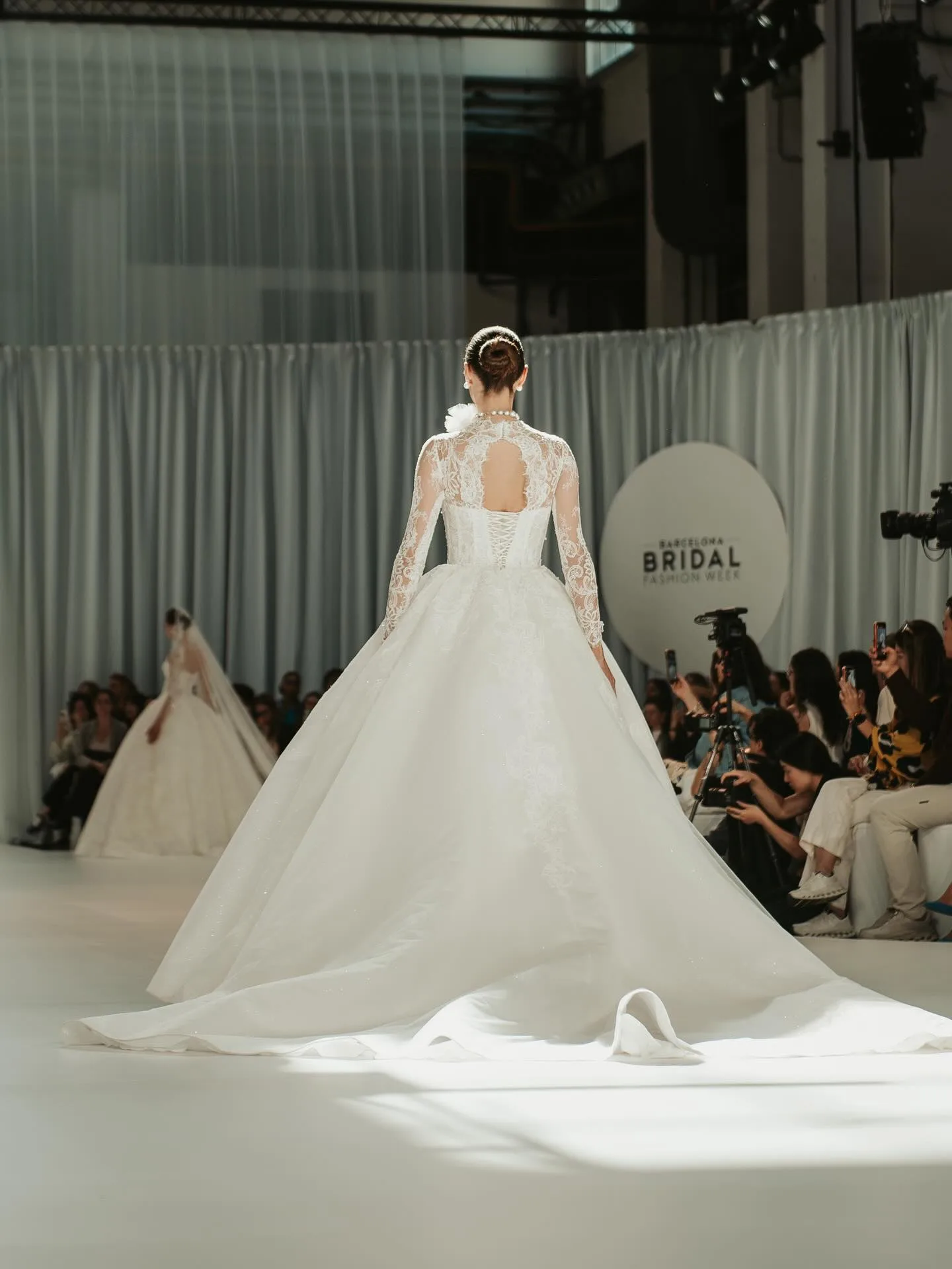 Modelo de costas com cauda de vestido de noiva em desfile