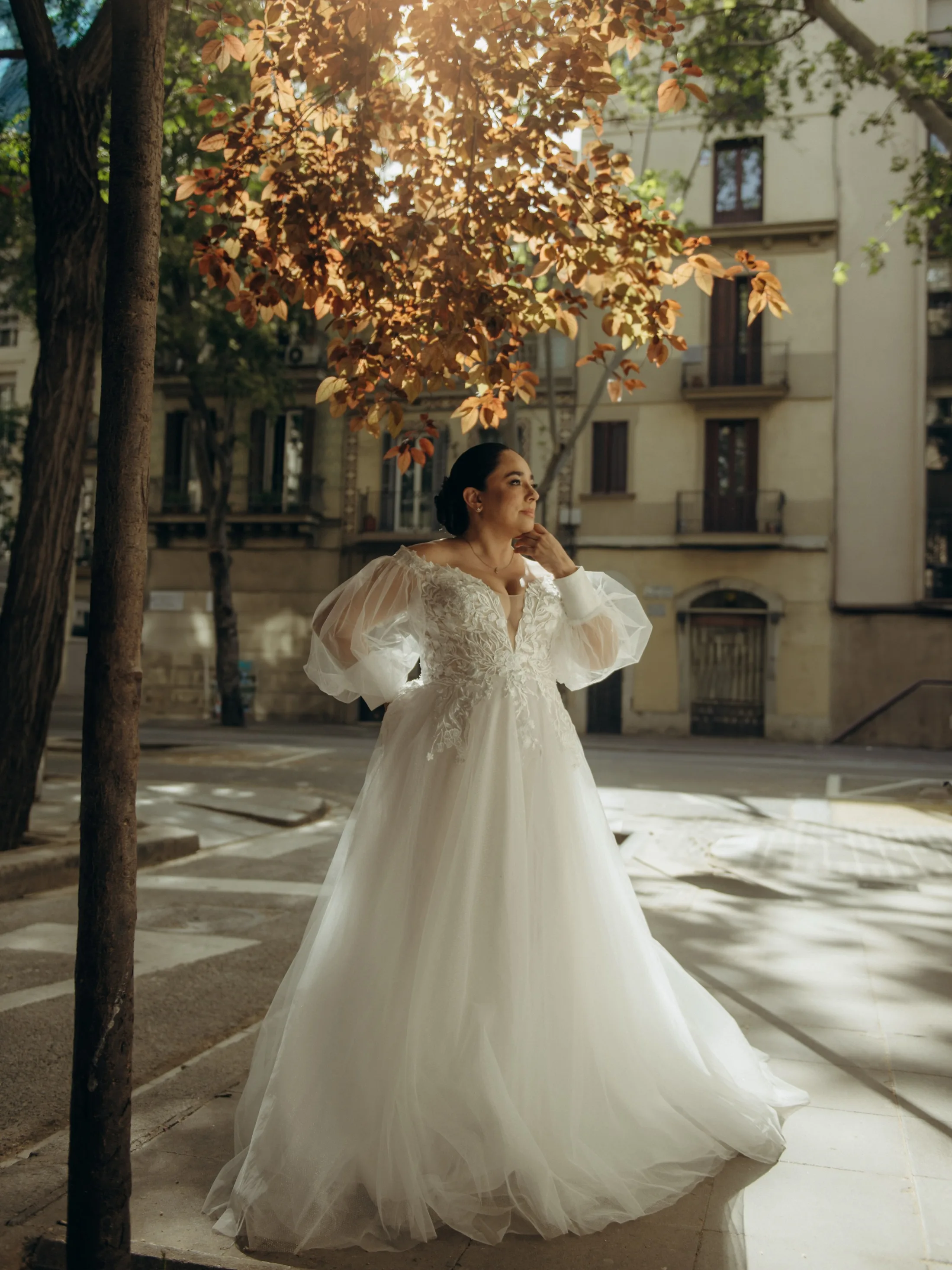 Mulher de vestido de noiva em rua arborizada